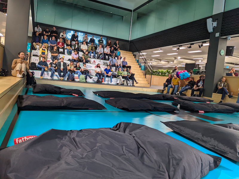 Photo from lower on the ground looking up at the audience on the bleachers at the Deliveroo Roo Pitch, with very few spaces left in the packed stands